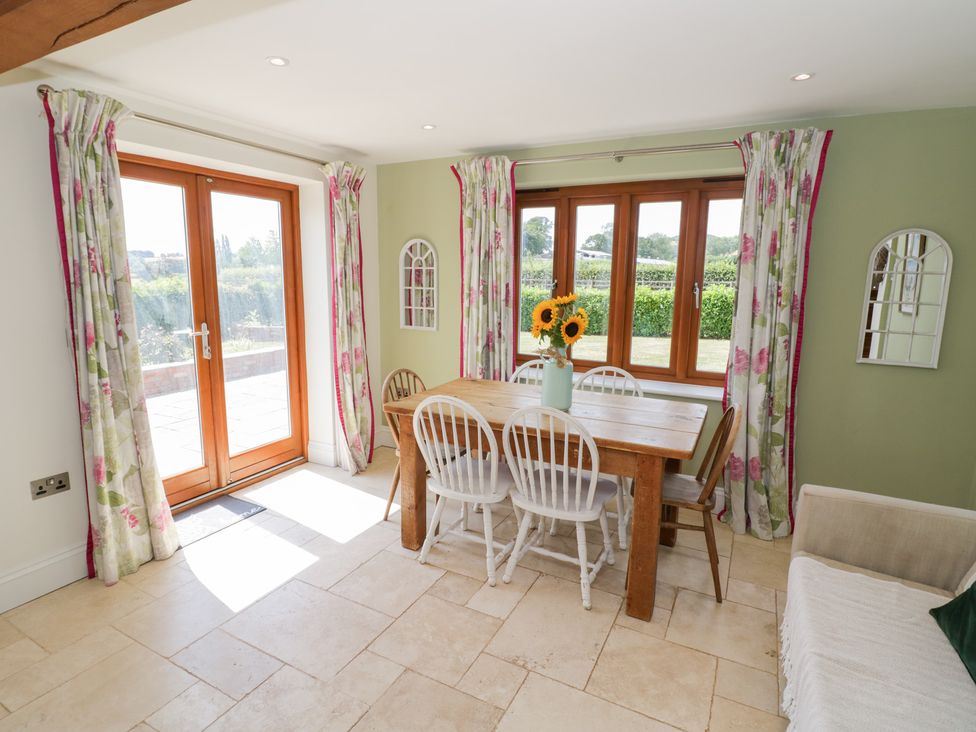 A dining room with a wooden table and chairs at Filly Brook in Bishop's Frome