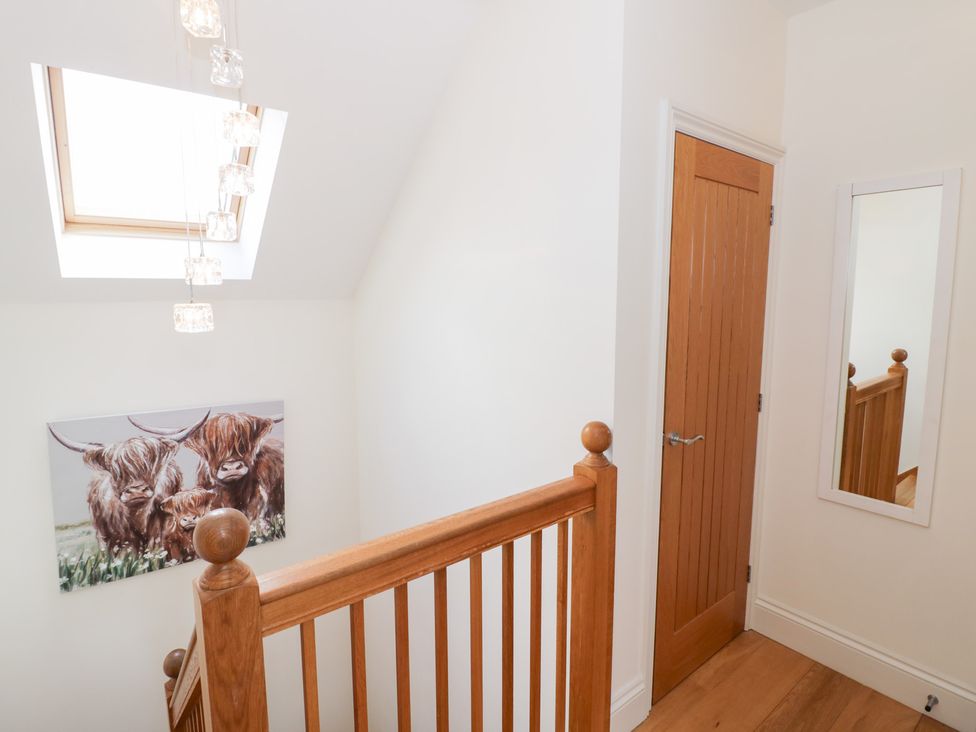 A hallway with a staircase and a painting at Filly Brook in Bishop's Frome