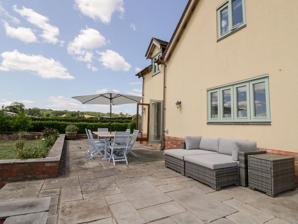An outdoor patio with a table and chairs at Filly Brook in Bishop's Frome