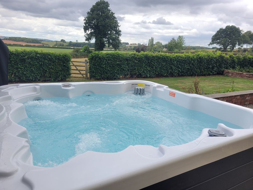 A hot tub with water outdoors at Filly Brook in Bishop's Frome