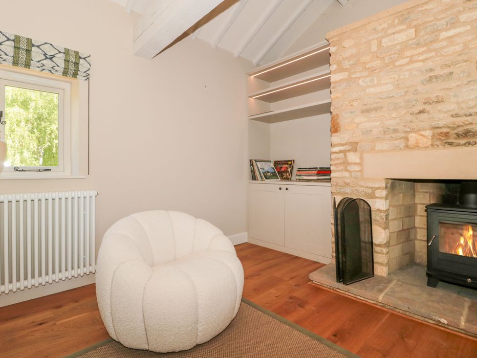 A living room with a chair and fireplace at Cleveley Mill in Enstone