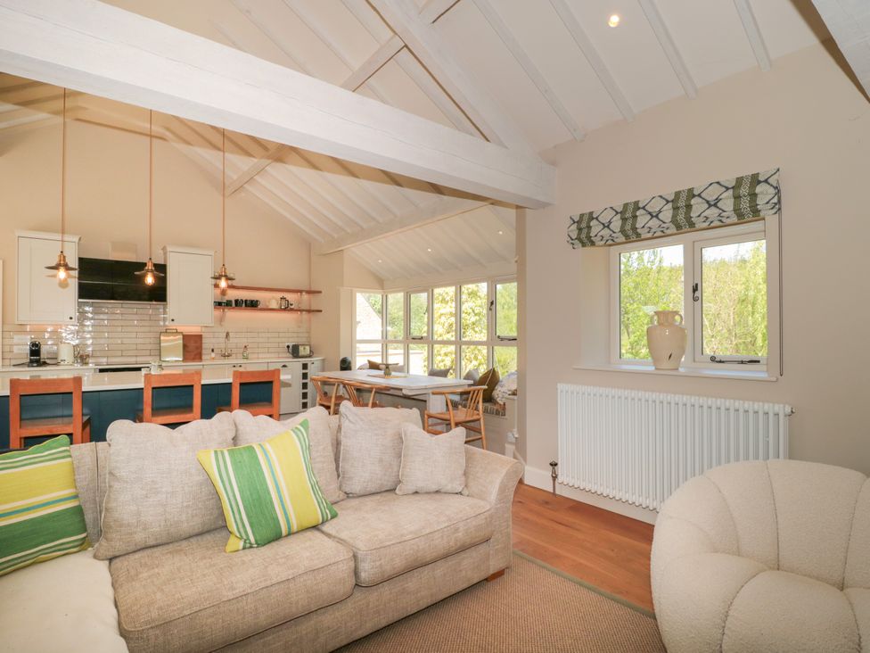 A living room with a kitchen island and dining area at Cleveley Mill Enstone