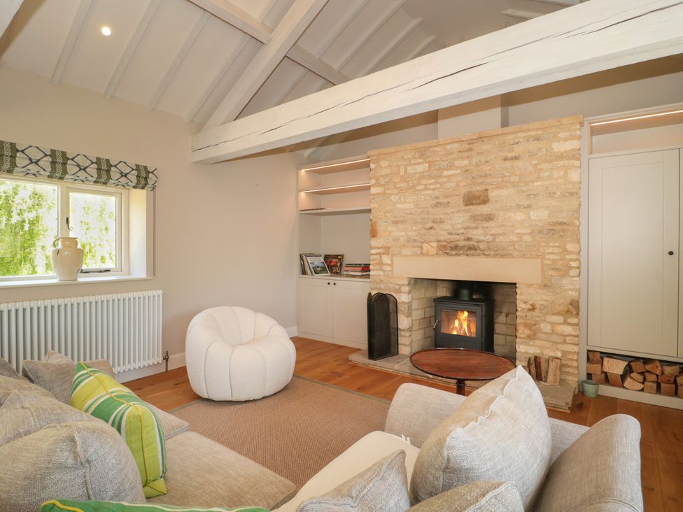 A living room with a fireplace and sofa at Cleveley Mill in Enstone