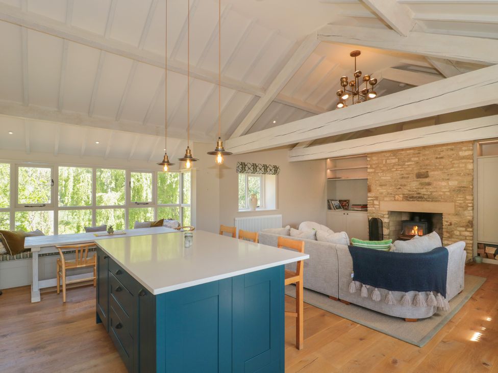 A living room with a kitchen island and sofa at Cleveley Mill in Enstone