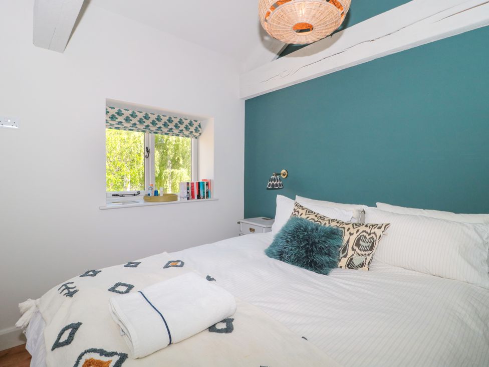 A bedroom with a bed and window at Cleveley Mill in Enstone