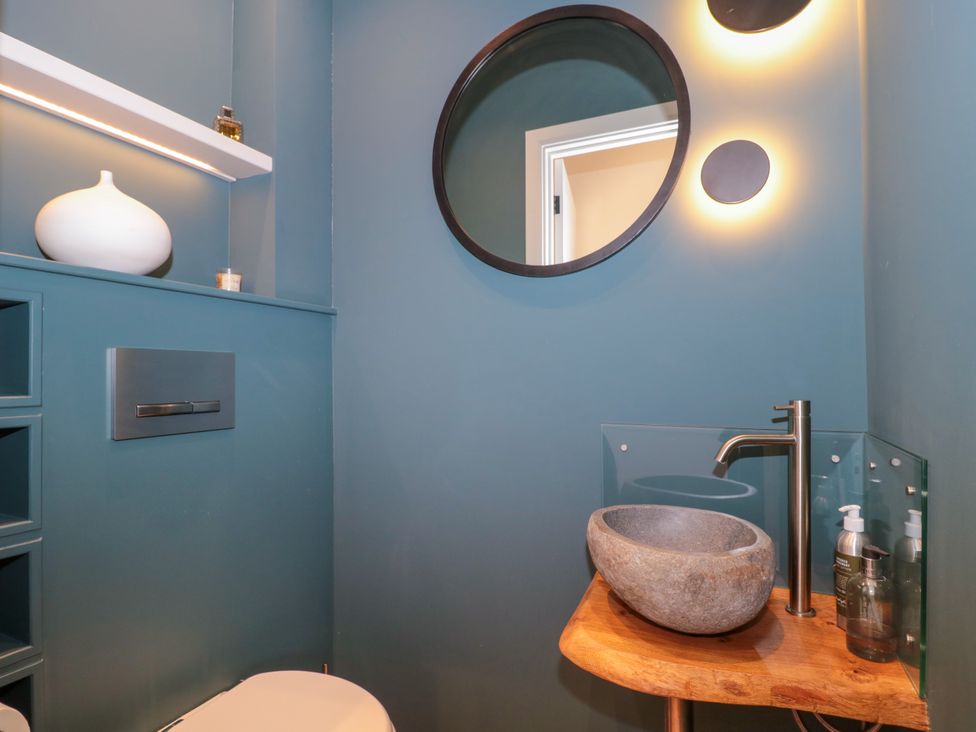 A bathroom with a toilet and a stone sink at Cleveley Mill in Enstone