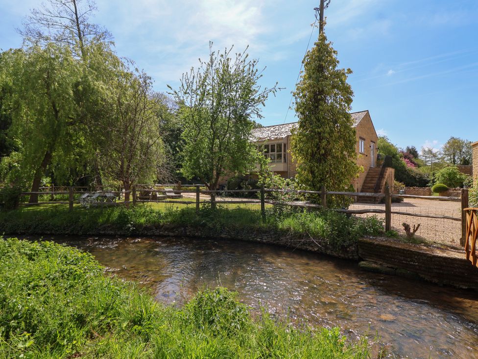 An outdoor area with a stream and trees at Cleveley Mill in Enstone