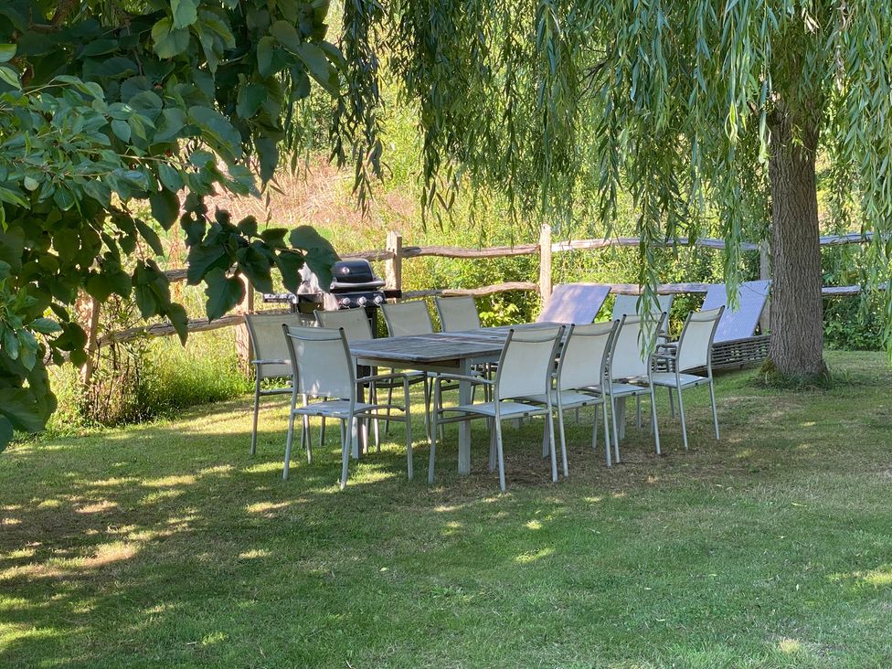 A garden with a table and chairs near a barbecue grill at The Annexe, Cleveley Mill, Chipping Norton