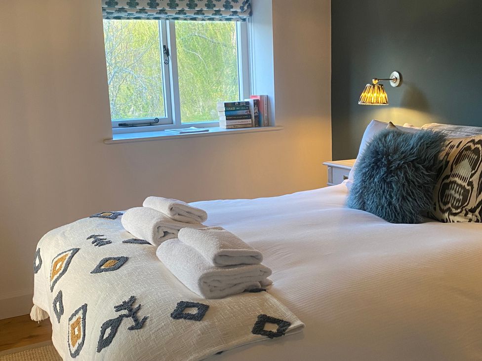 A bedroom with a bed and towels on it at The Annexe, Cleveley Mill in Chipping Norton