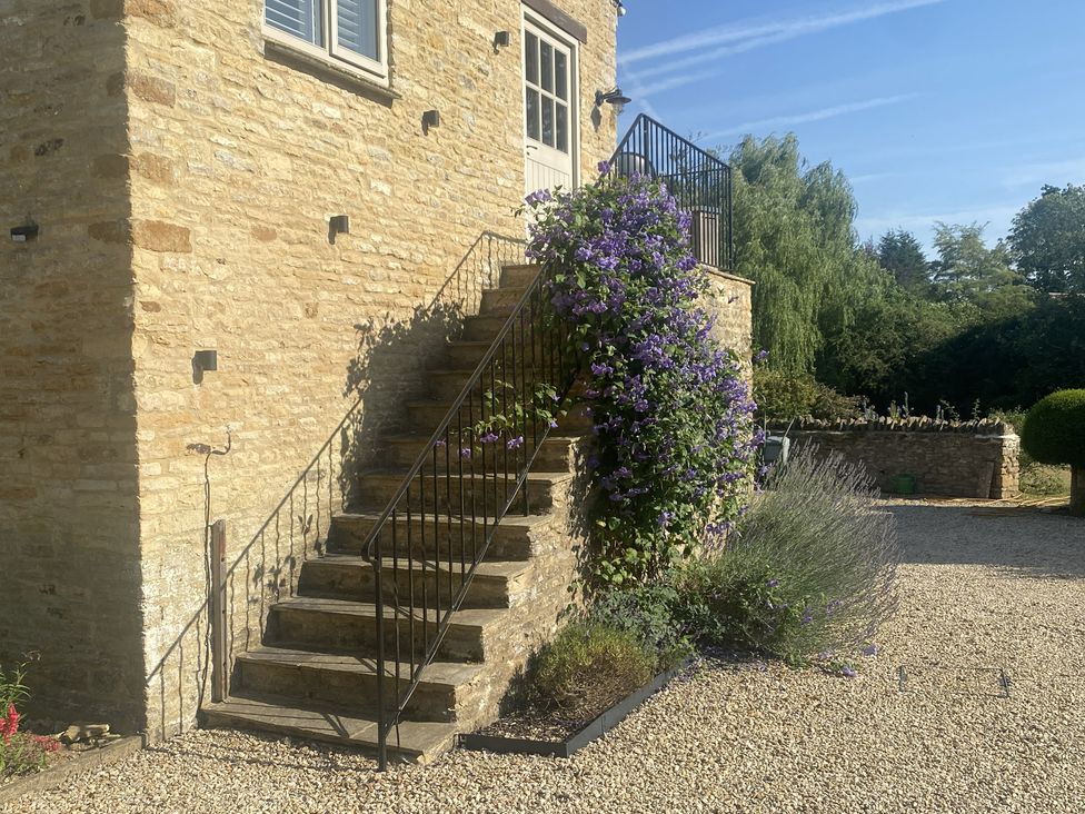A set of stairs with flowering plants leading to a building at The Annexe, Cleveley Mill Enstone