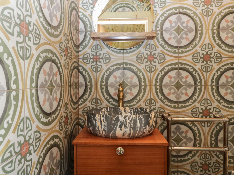 A bathroom with a sink and mirror at Shepherd Hut’s in Bristol