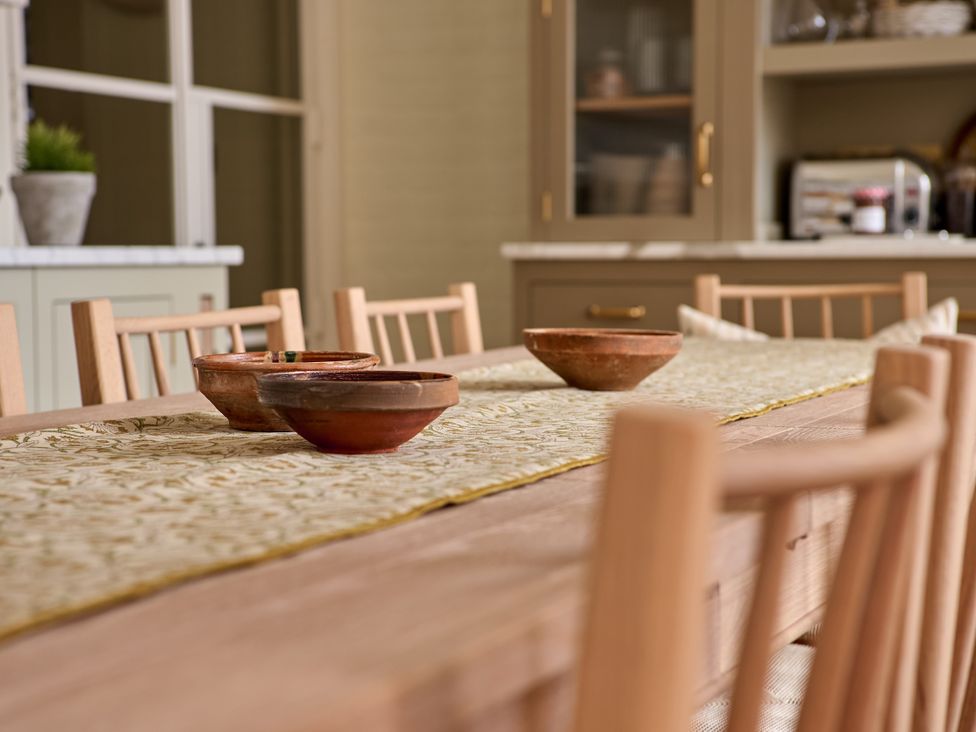 A dining room with a wooden table and clay bowls at Castle Corner, The Georgian House in Ludlow