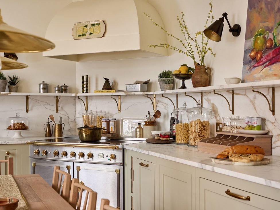 A kitchen with stove, shelves, jars, pasta, and utensils at Castle Corner, The Georgian House, Ludlow
