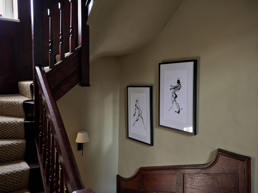A staircase with artwork on the wall at Castle Corner, The Georgian House in Ludlow