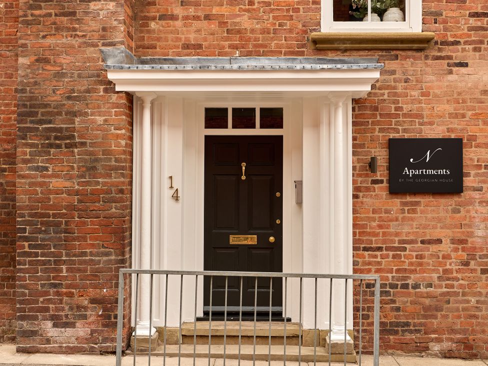 An entrance with a black door and a sign at Castle Corner, The Georgian House in Ludlow