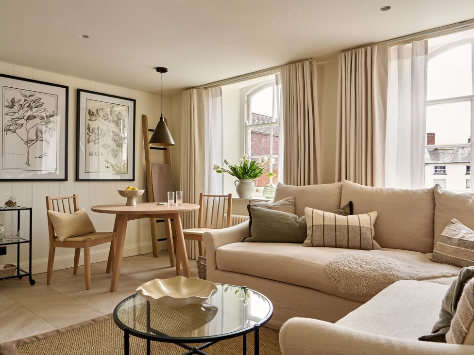 A living room with a sofa and a dining table at Market View - The Georgian House Ludlow