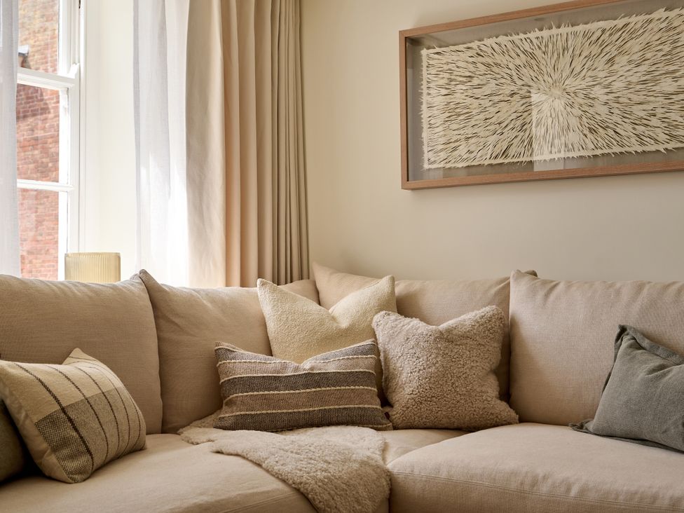 A living room with a couch and decorative pillows at Market View - The Georgian House in Ludlow