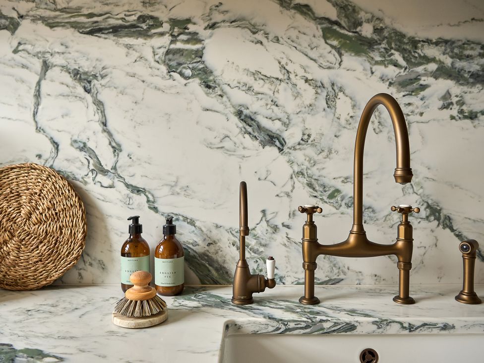 A kitchen sink with a faucet and soap dispensers at Market View - The Georgian House in Ludlow