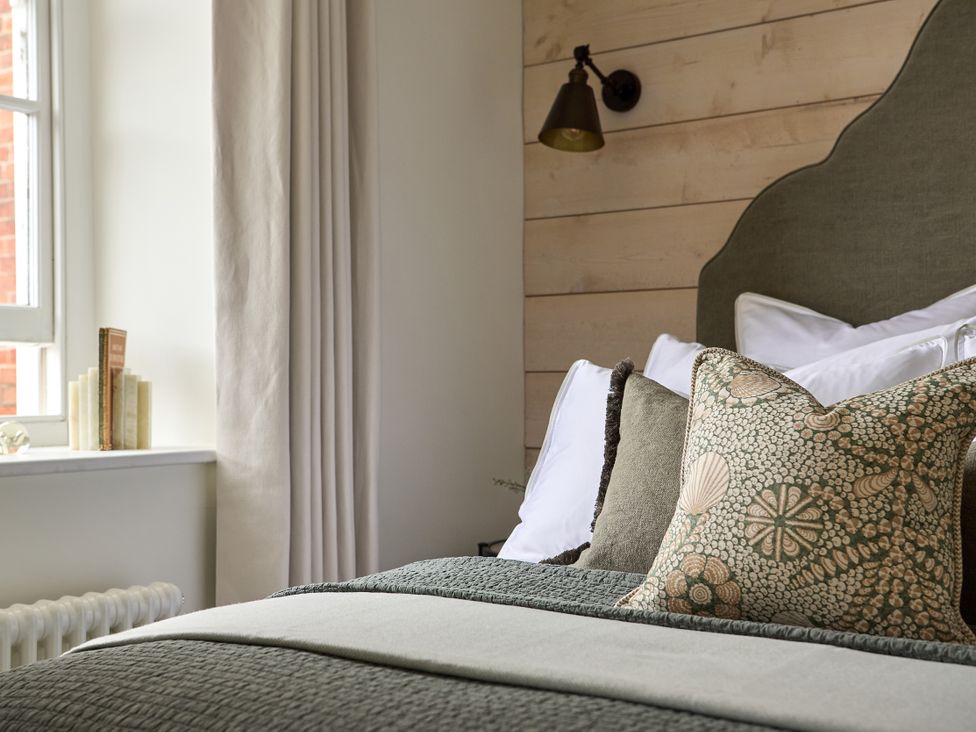 A bedroom with a bed and decorative pillows at Market View - The Georgian House, Ludlow