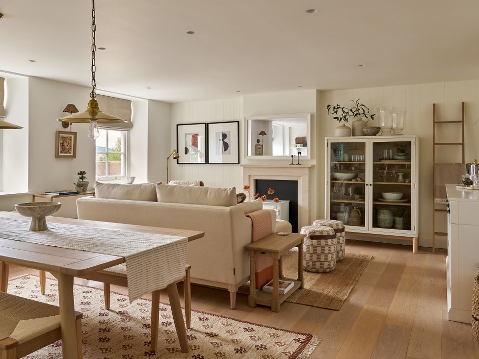 A living room with a sofa, dining table, and glass cabinet at Stretton Hills Peaks - The Georgian House, Ludlow