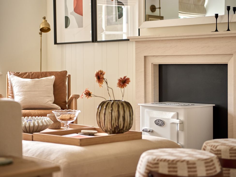 A living room with a chair and fireplace at Stretton Hills Peaks - The Georgian House in Ludlow