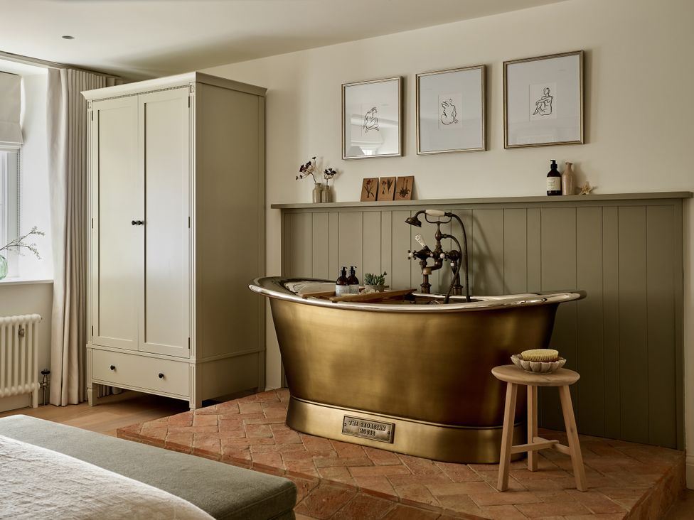 A bathroom with a bathtub and wardrobe at Stretton Hills Peaks - The Georgian House, Ludlow
