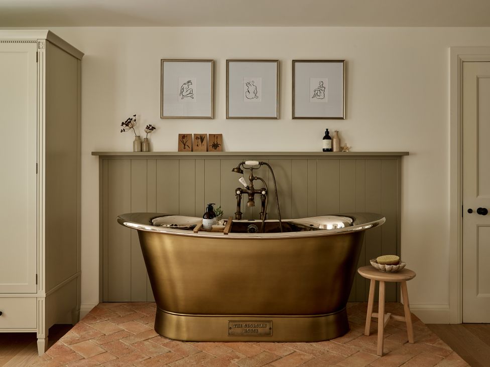 A bathroom with a bathtub and wall art at Stretton Hills Peaks - The Georgian House in Ludlow