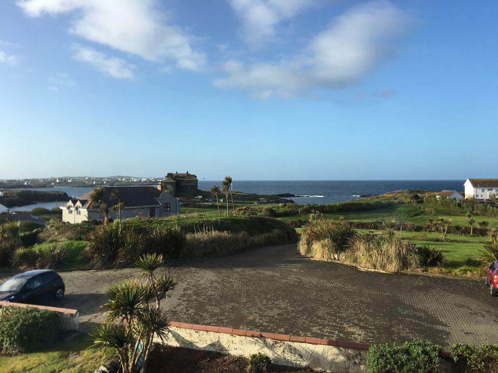 A view of the ocean and houses with a car in the foreground at Lady of the Lake Suite