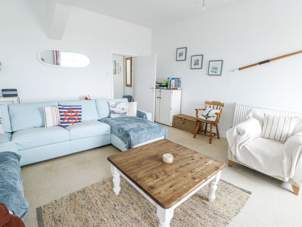 A living room with a sofa and coffee table at Lady of the Lake Suite in Trearddur Bay