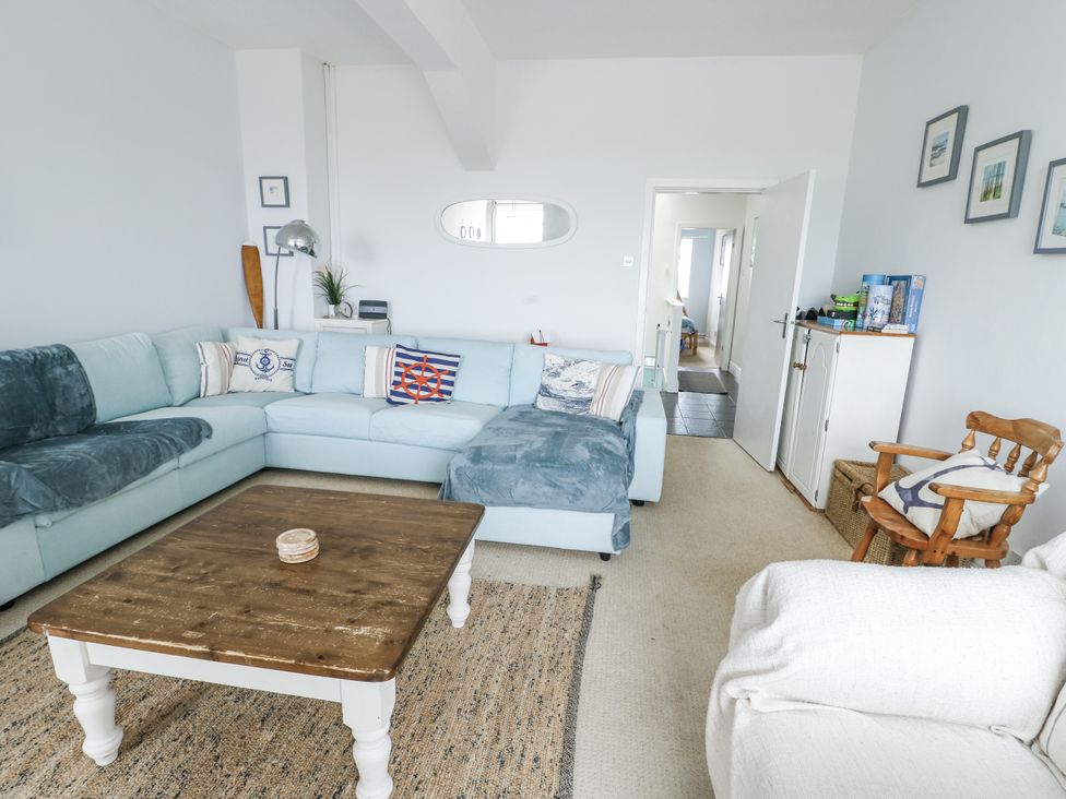 A living room with a sofa and coffee table at Lady of the Lake Suite Trearddur Bay