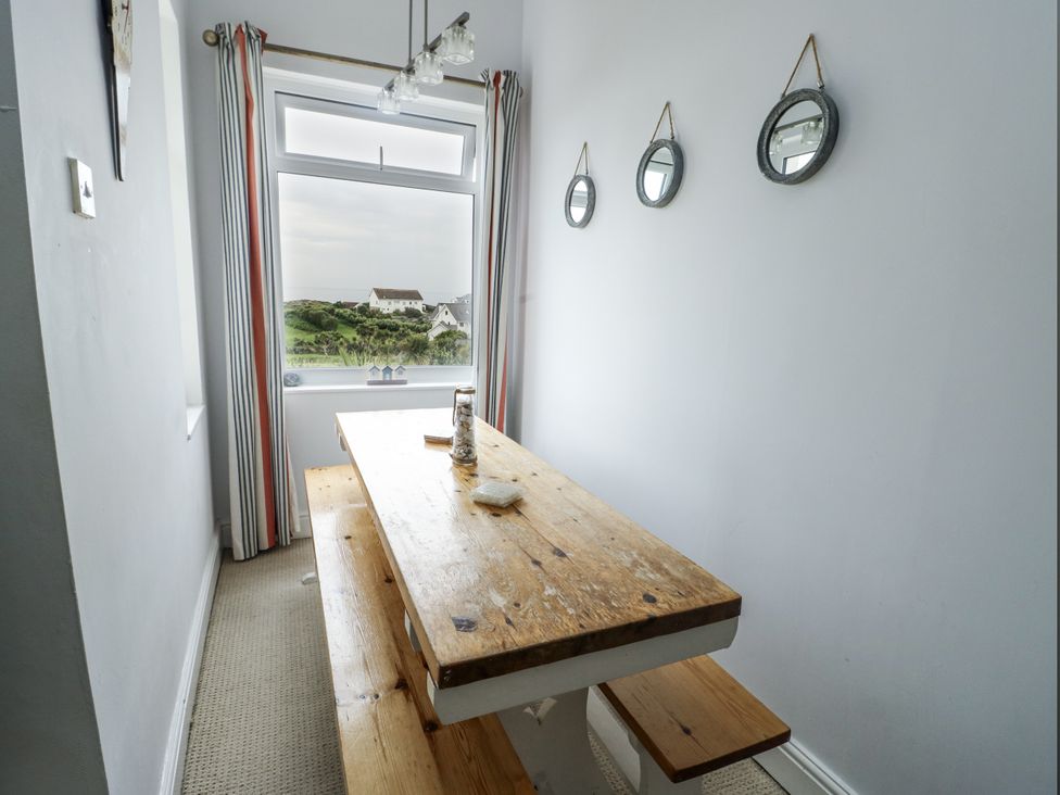 A dining room with a wooden table and chairs at Lady of the Lake Suite Trearddur Bay