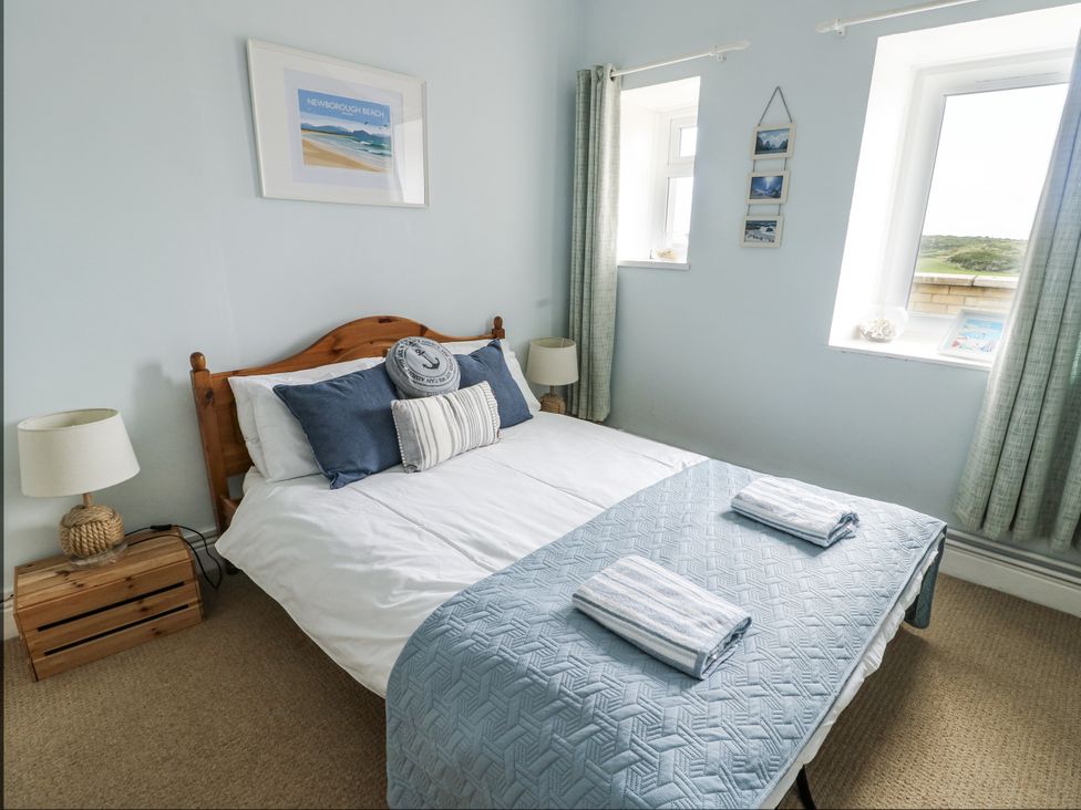 A bedroom with a bed and a bedside table at Lady of the Lake Suite Trearddur Bay