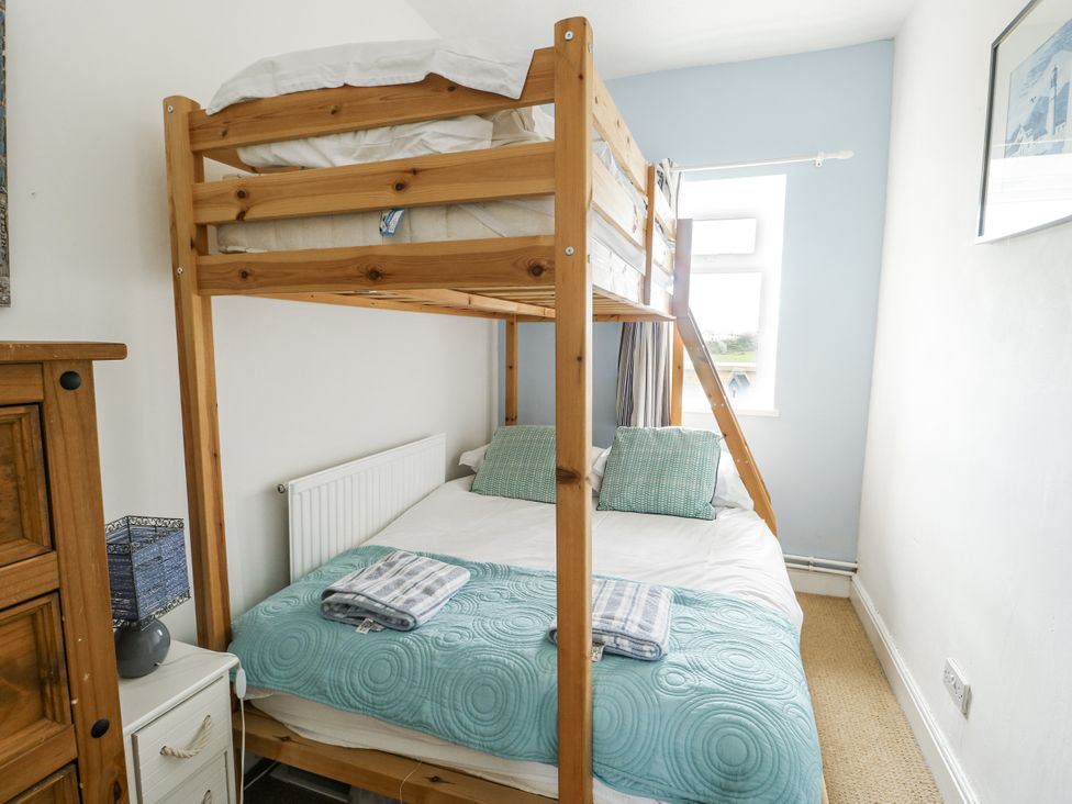 A bedroom with a bunk bed and a double bed at Lady of the Lake Suite Trearddur Bay