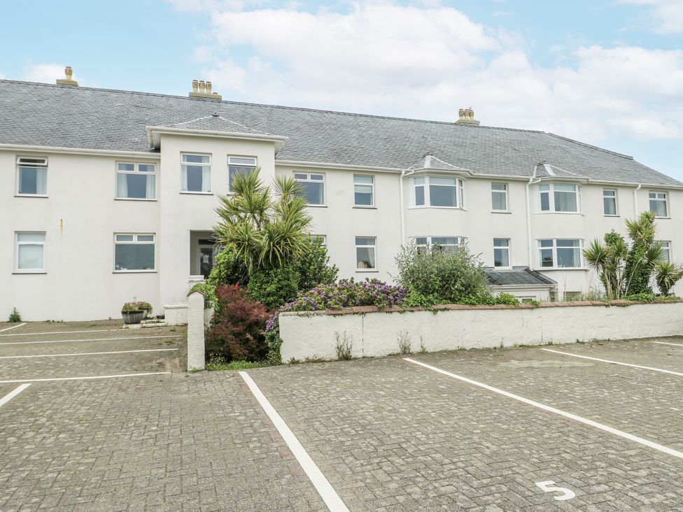 An outdoor view of a building with parking spaces at Lady of the Lake Suite in Trearddur Bay