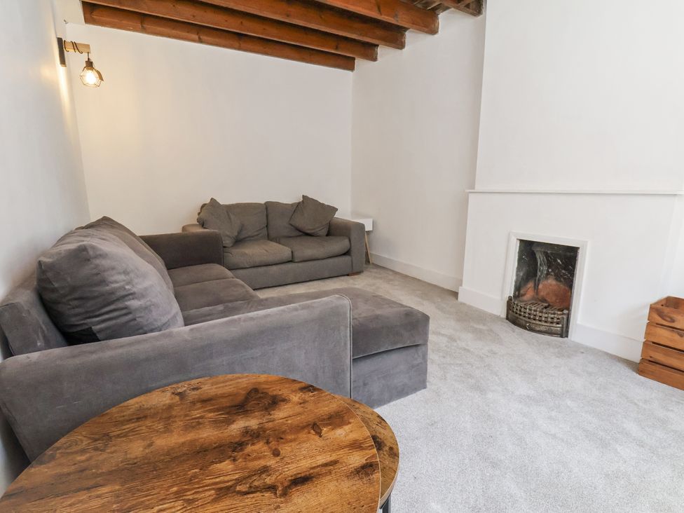 A living room with a sofa and a fireplace at Hemdin Cottage in Thornton Dale