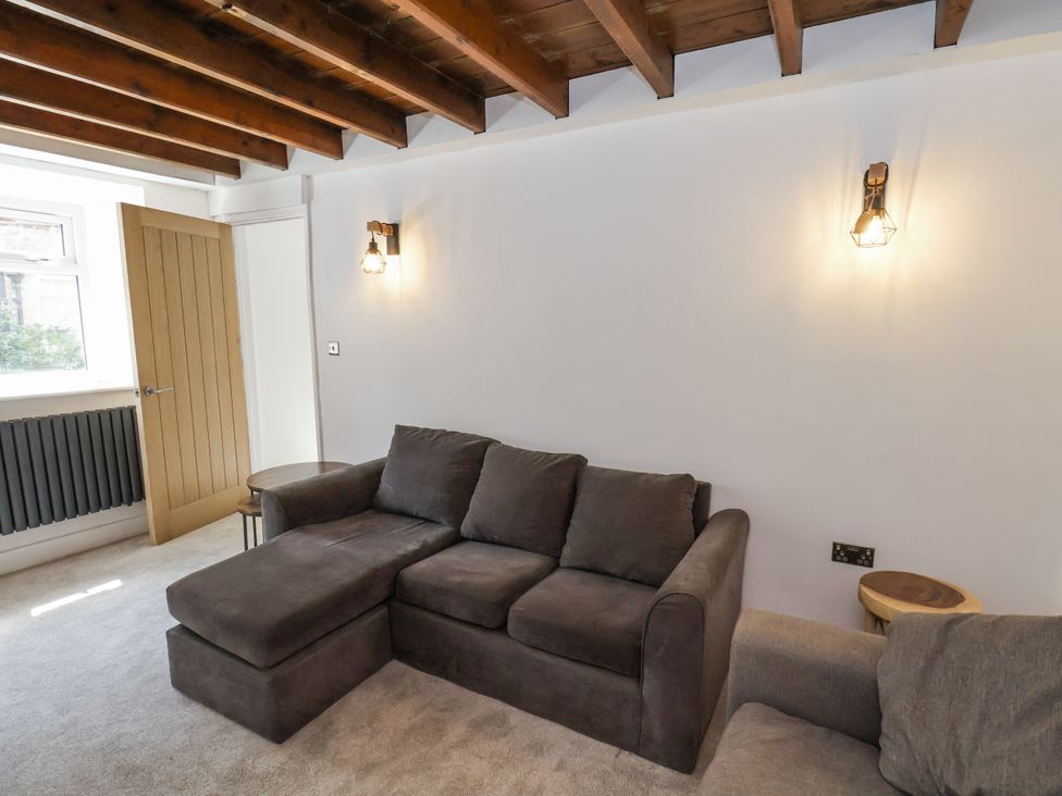 A living room with a sofa and a door at Hemdin Cottage in Thornton Dale