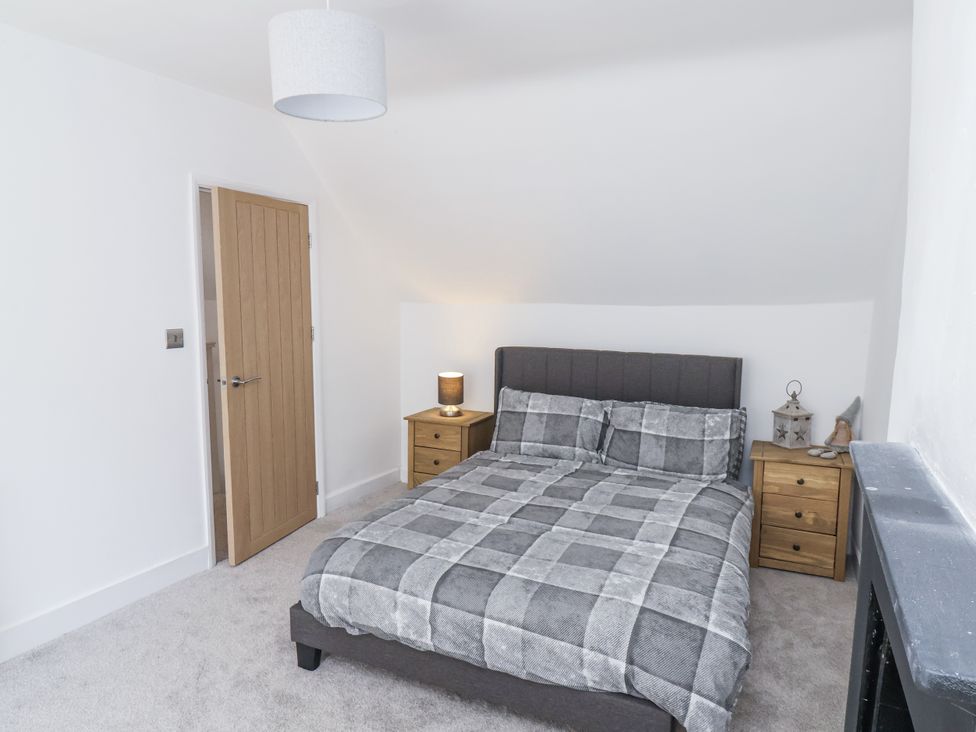 A bedroom with a bed and nightstands at Hemdin Cottage in Thornton Dale