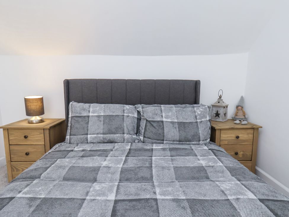 A bedroom featuring a bed with pillows and nightstands at Hemdin Cottage in Thornton Dale