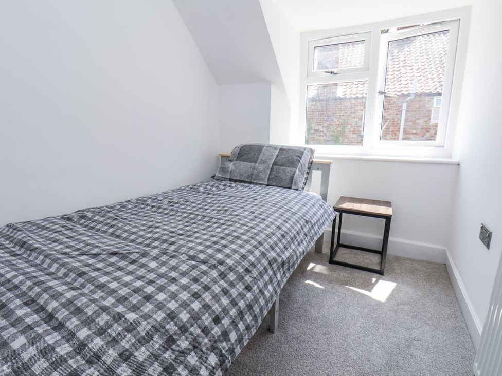 A bedroom with a bed and side table at Hemdin Cottage in Thornton Dale
