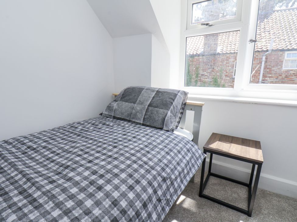 A bedroom with a bed and bedside table at Hemdin Cottage in Thornton Dale