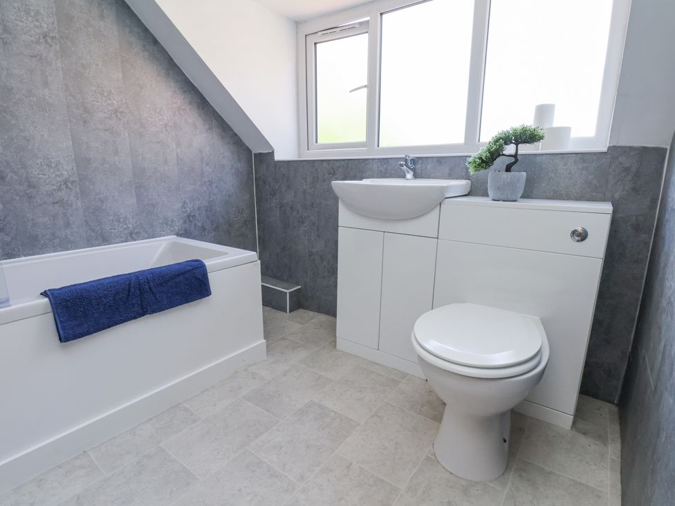 A bathroom with a bathtub and toilet at Hemdin Cottage in Thornton Dale