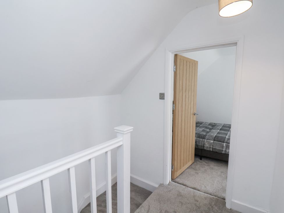 A staircase leading to a bedroom with a bed at Hemdin Cottage in Thornton Dale