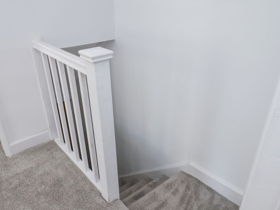 A staircase with a white handrail at Hemdin Cottage in Thornton Dale