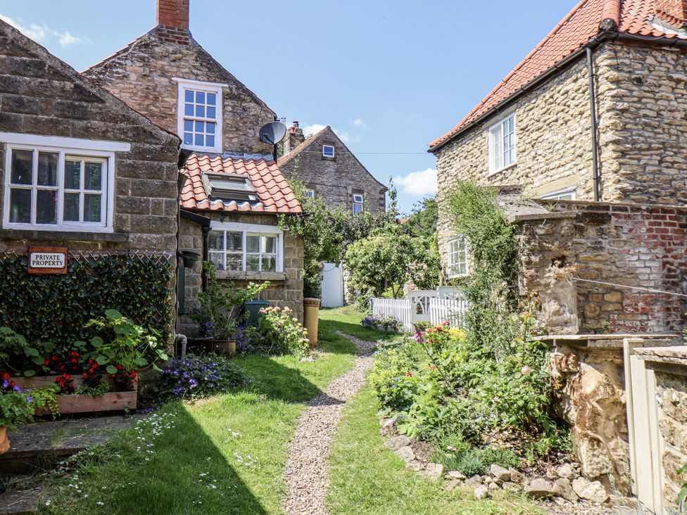 An outdoor area with a pathway and flowers at Hemdin Cottage Thornton Dale