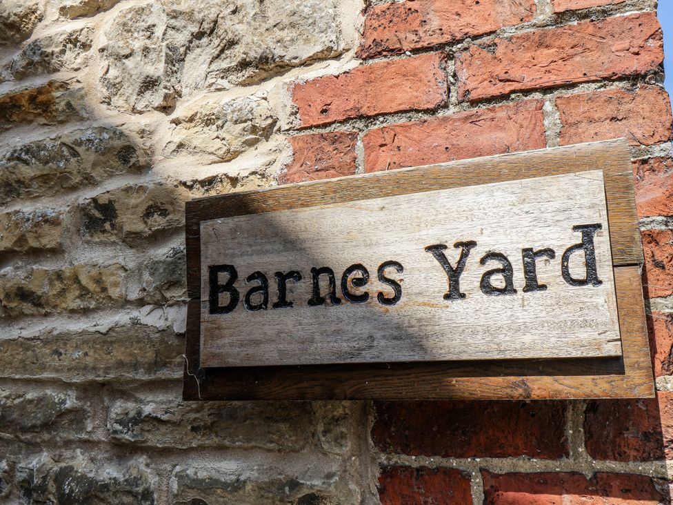 A sign that reads Barnes Yard on a stone and brick wall at Hemdin Cottage Thornton Dale