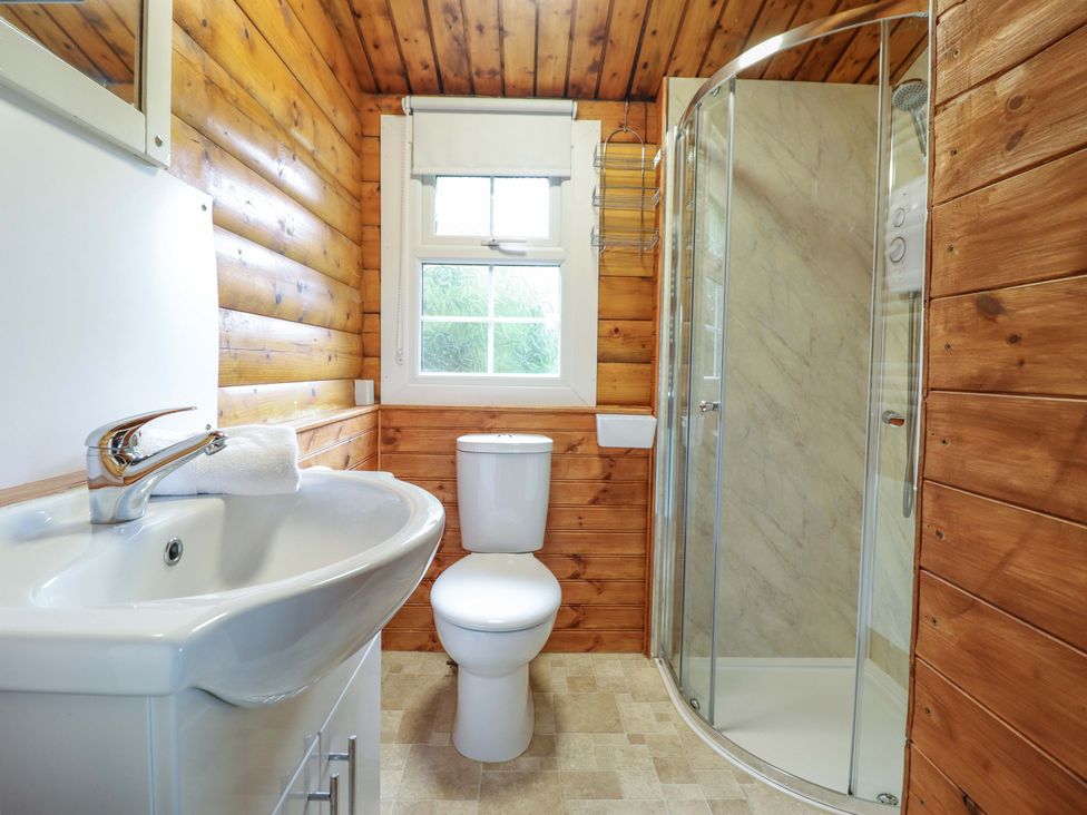 A bathroom with a sink, toilet, and shower at Y Bwthyn Pren, Cabin 209, Trawsfynydd
