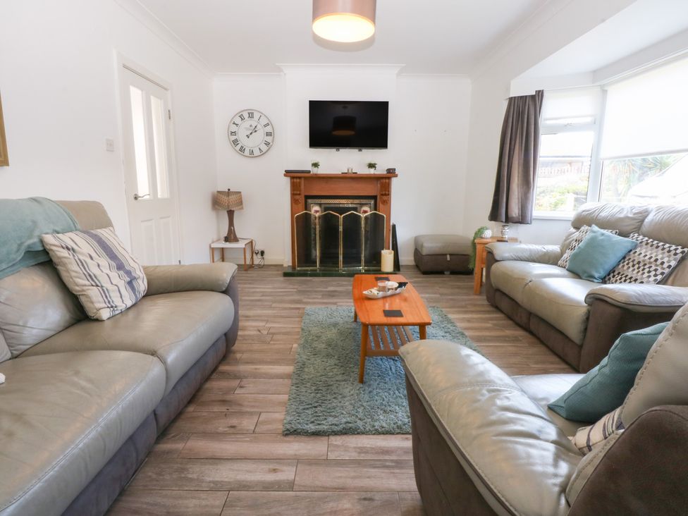 A living room with sofas and a fireplace at Seabreeze in Llandudno