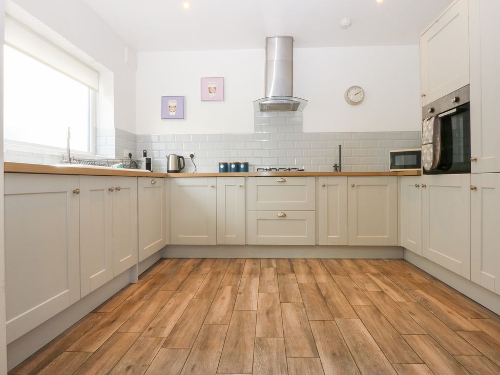 A kitchen with a sink and stove at Seabreeze in Llandudno