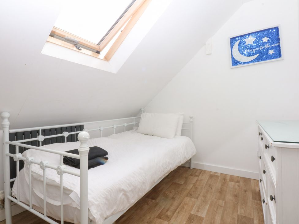 A bedroom with a single bed and a dresser at Seabreeze in Llandudno