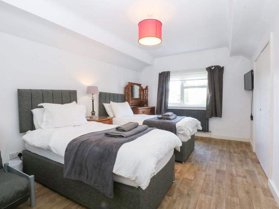 A bedroom with two beds and a dressing table at Seabreeze in Llandudno